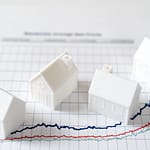 Illustration de maisons miniatures sur un graphique représentant la variation des taux d’emprunt immobilier en 2025.