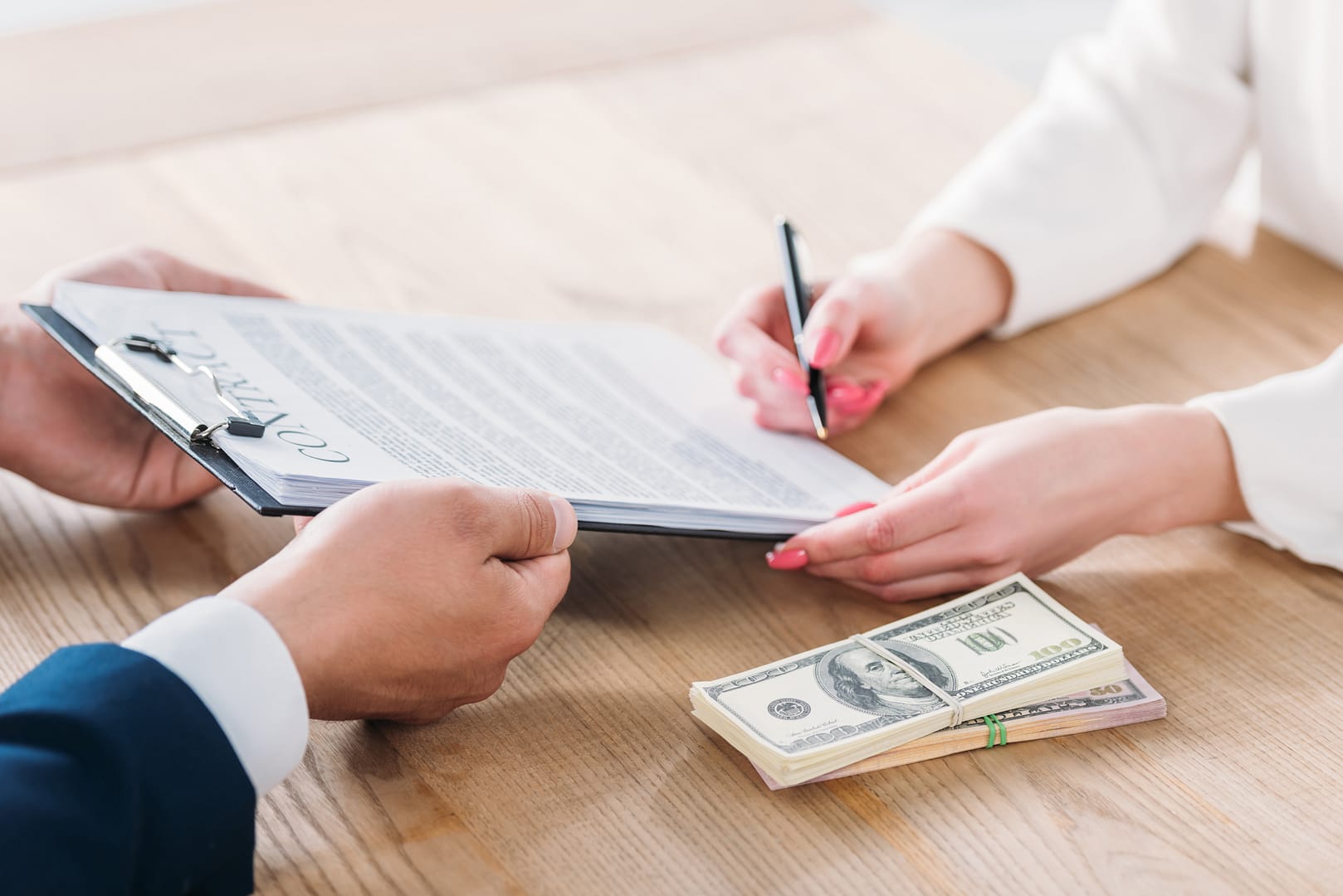 Signature d’un contrat d’assurance avec remise d’argent sur la table – illustration du financement d’un contrat obsèques
