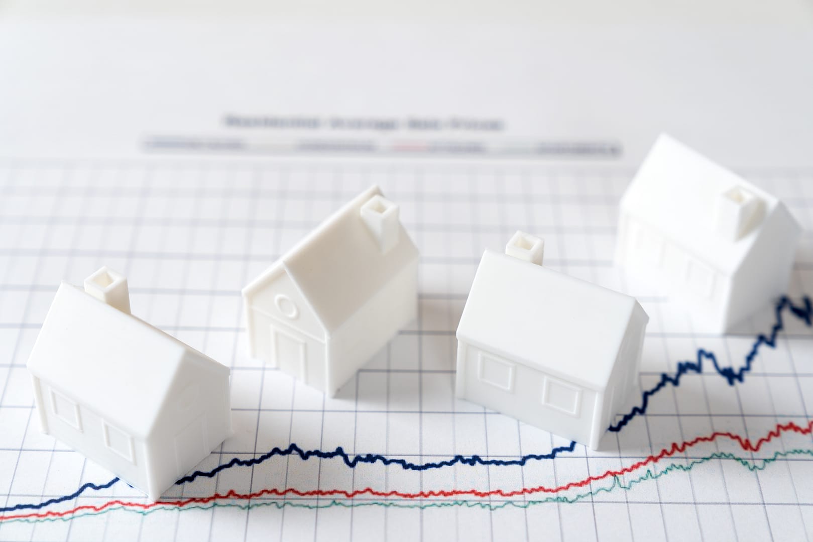 Illustration de maisons miniatures sur un graphique représentant la variation des taux d’emprunt immobilier en 2025.