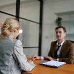 entretien d'embauche entre une femme blonde et un homme d'âge moyen dans un bureau d'entreprise