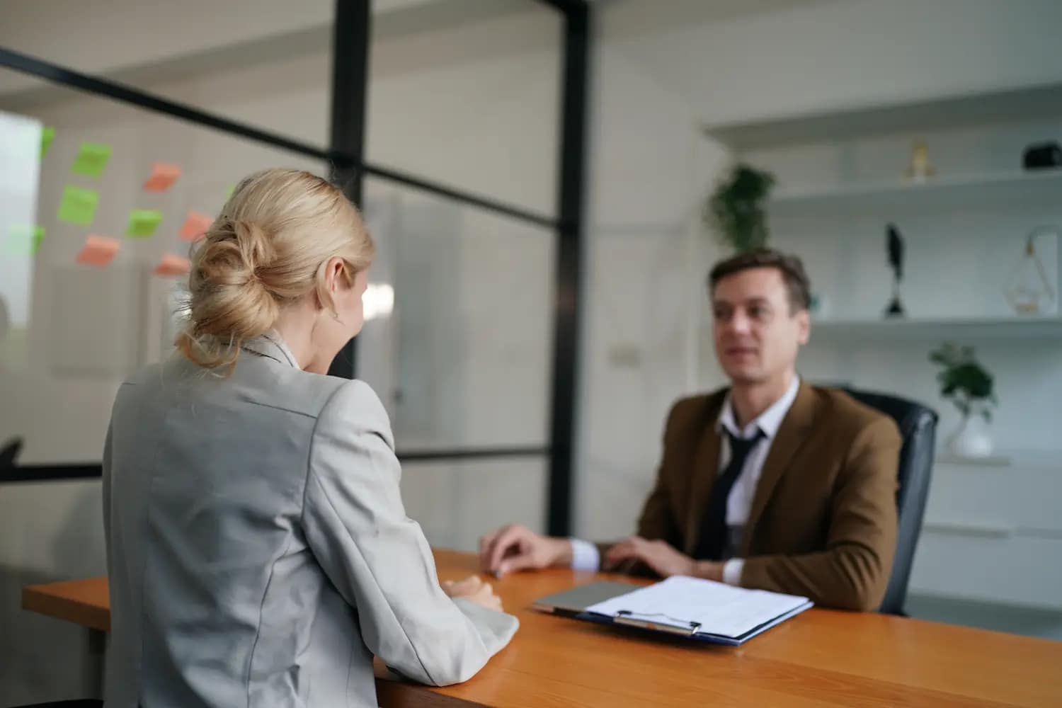 entretien d'embauche entre une femme blonde et un homme d'âge moyen dans un bureau d'entreprise