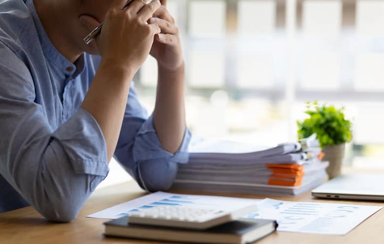 un homme stressé qui étudie la comptabilité à son bureau